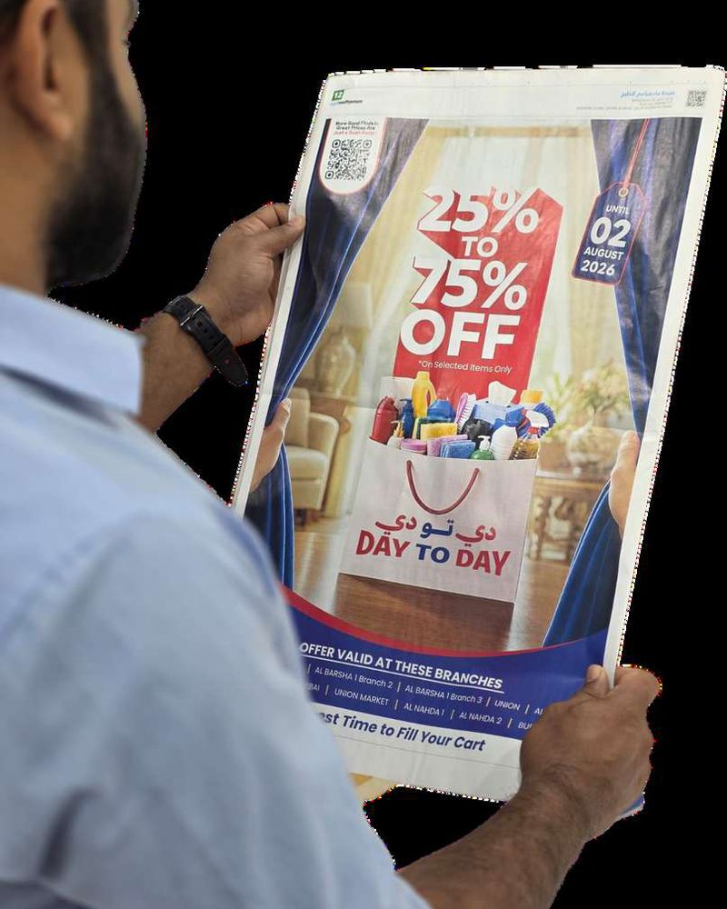Day To Day UAE 25% to 75% Off frontpage newspaper advertisement campaign held in hands